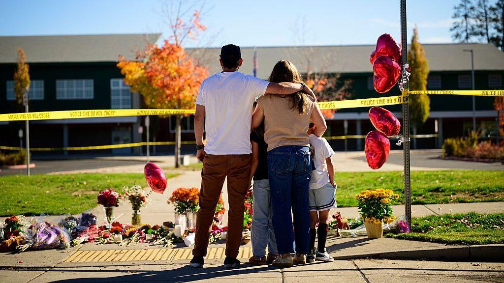Community members grieve at the site of the memorial at Silver Rail Elementary School