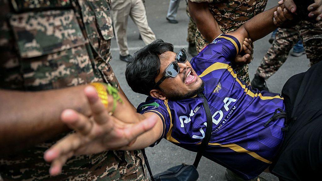 Security personnel detain a demonstrator at Jantar Mantar, New Delhi